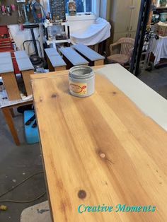 a can of paint sitting on top of a wooden table in a room filled with furniture