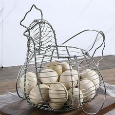 a metal basket filled with eggs on top of a wooden table