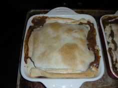 two pans filled with food sitting on top of a table