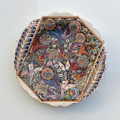 a decorative bowl is sitting on a white surface