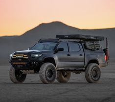 the truck is parked in the desert at sunset