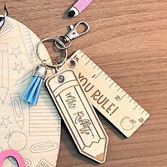 a pair of scissors, ruler and paper cutouts on a wooden table with writing