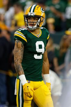 a football player in green and yellow uniform