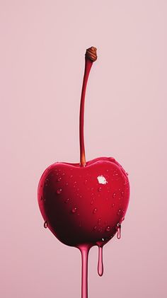 a heart shaped object with water drops on it's side and a pink background