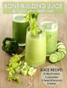 two glasses filled with green juice next to cucumbers and broccoli