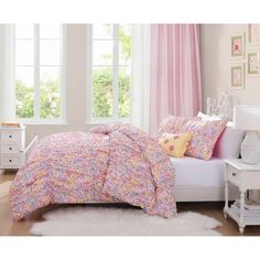 a bedroom with pink and white bedding, window curtains and rugs on the floor