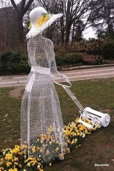 a woman with a lawn mower and flowers in front of her is made out of wire