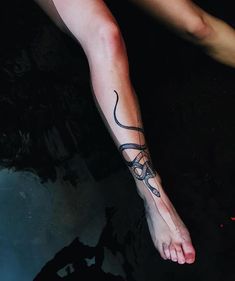 a person with a snake tattoo on their foot