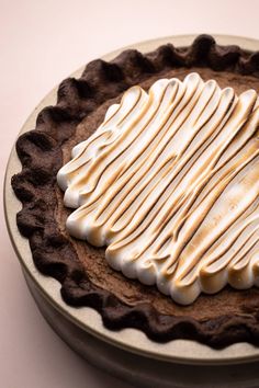 a chocolate pie with white frosting on top