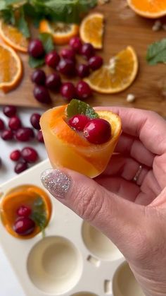 a hand holding an orange and cranberry jello