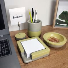 a laptop computer sitting on top of a desk next to a cup and pen holder