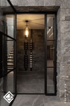 Luxurious wine cellar room with stone walls and glass doors.