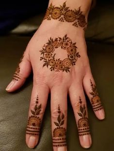 a woman's hand with hennap on it and flowers around the wrist