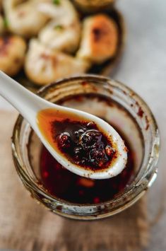 a spoon full of chili garlic sauce in a glass jar with the title above it