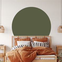 a bedroom with a large green circle wall decal on the wall above the bed