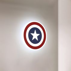 the captain's shield logo is lit up in front of a white wall and ceiling