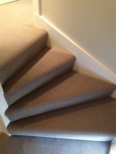 a carpeted staircase leading up to the top floor