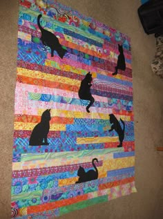 a quilt with cats on it is laying on the floor