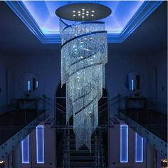 a large chandelier hanging from the ceiling in a room filled with stairs and lights