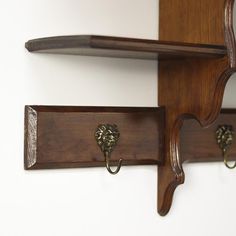 two wooden shelves with hooks on them and one has a coat rack attached to the wall