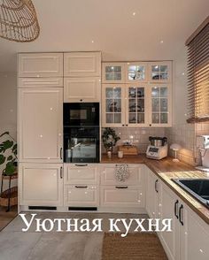 a kitchen with white cabinets and wooden counter tops