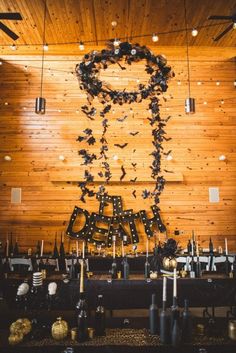 the table is set up with black and gold decorations, candles, and wine bottles