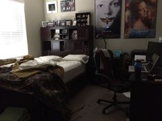 a bedroom with a bed, desk and posters on the wall