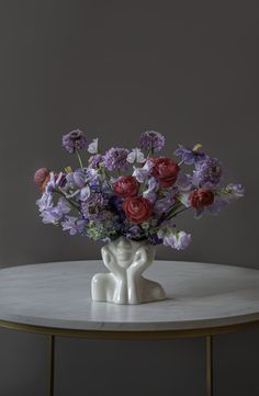 a vase filled with purple and red flowers on top of a table