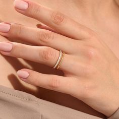 a woman's hand with two rings on her left and one ring on her right