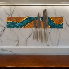 two knives are hanging on a marble wall