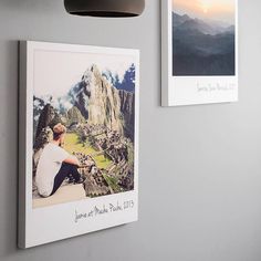 two pictures hang on the wall next to a lamp and a light fixture with a photo hanging from it