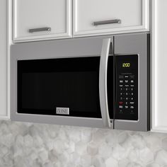 a close up of a microwave in a kitchen with white cabinets and marble counter tops