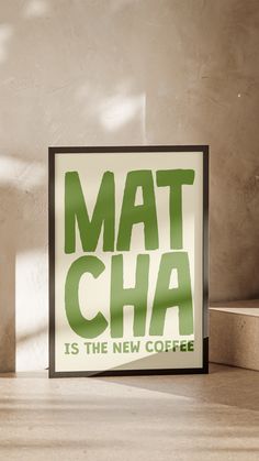 a sign that says mat cha is the new coffee next to a cup on a table