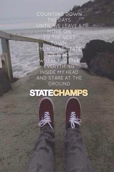 someone is standing on the edge of a pier with their feet propped up against the railing