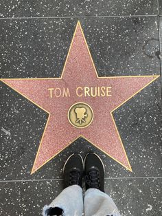 a person standing in front of a star on the hollywood walk of fame with their feet up