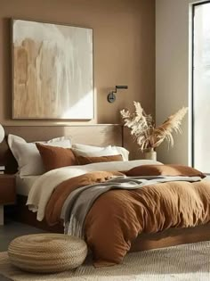 a bedroom with brown and white bedding in the corner, an art piece on the wall