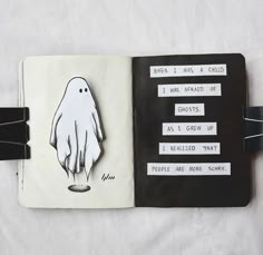 an open notebook with a drawing of a hand holding a ghost on it's cover