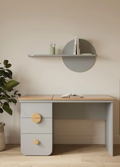 an office desk with two drawers and a plant