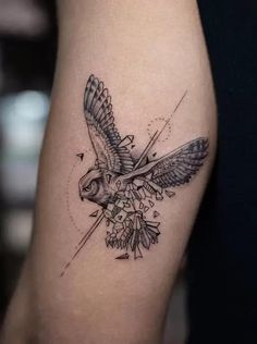 a small tattoo on the leg of a woman with an owl and flowers in it