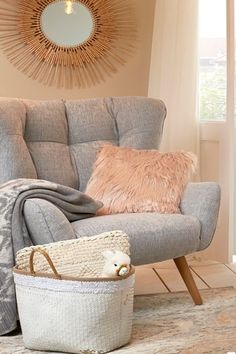 a living room with a chair, rug and basket in front of a mirror on the wall