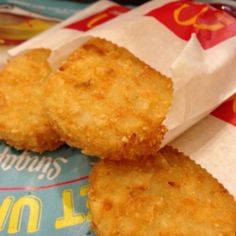 three fried food items sitting on top of a wrapper