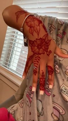 a woman's hand with henna tattoos on it