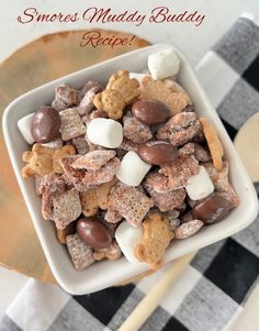 a white bowl filled with marshmallows and chocolate chip muddy dog treats on top of a checkered table cloth