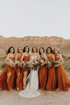 a group of women standing next to each other in front of a desert mountain range