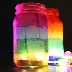 two jars filled with colored liquid sitting next to each other on top of a table