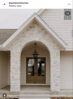 a white house with two doors and steps leading to the front door