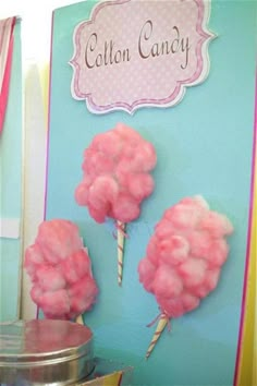 cotton candy sticks are on display in front of a blue sign that says cotton candy