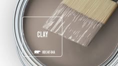 a paint can with a brush in it and the words clay on top of it