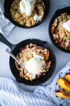 three skillets filled with fruit and ice cream on top of a white tablecloth