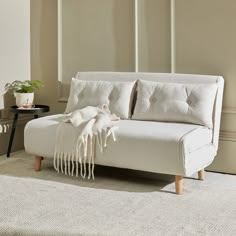 a white couch sitting on top of a rug in a living room